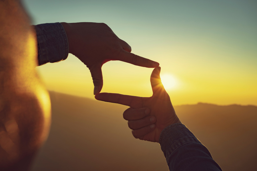 Person looking into the distance using their hands to determine what the future will look like