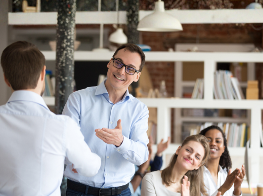 Middle aged boss, mentor congratulating employee, shaking hand